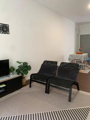 a living room with two chairs and a tv at Ereens homestay 3 bedroom apartment in Brinchang