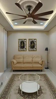 a living room with a couch and a ceiling fan at Zulfa Homestay Teluk Intan in Teluk Intan