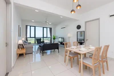a dining room and living room with a table and chairs at Jazz Luxury Suites BY MEXI in Tanjong Tokong