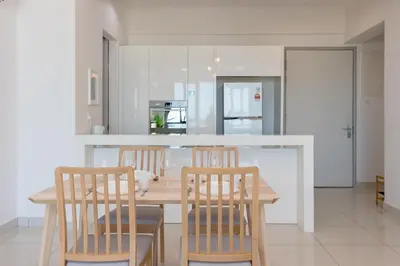a kitchen with a wooden table and four chairs at Jazz Luxury Suites BY MEXI in Tanjong Tokong
