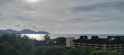 a view of a building with the ocean in the background at Bayu Emas Apartment in Batu Ferringhi