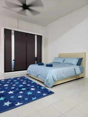 a bedroom with a bed and a blue rug at Dirgahayu Homestay I Rajawali in Kulim