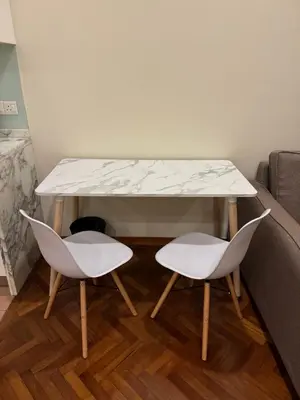a table with two chairs and a white marble top at Sweet Cozy Marina Suite at Straits Quay in Tanjong Tokong