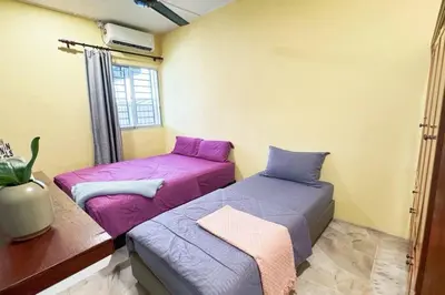 two beds sitting next to each other in a room at Bercham 81 Homestay in Ipoh