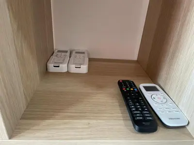 three remote controls sitting in a wooden box at the Anderson Ipoh 2BR by Goswell in Ipoh
