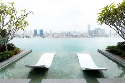 two white chairs sitting next to a body of water at Beacon Executive Suite by MAY in George Town
