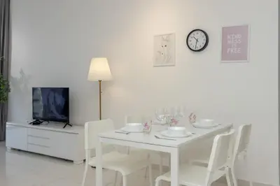 a white dining room with a white table and chairs at Beacon Executive Suite by MAY in George Town