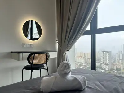 a bedroom with a bed with a mirror and a chair at Urban Suites Cozy Home with Netflix and Board games in Jelutong