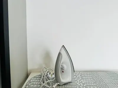 a bed with a iron on top of it at Urban Suites Cozy Home with Netflix and Board games in Jelutong