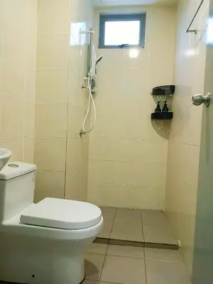 a bathroom with a toilet and a shower with a window at Cameron Palas Homestay in Brinchang