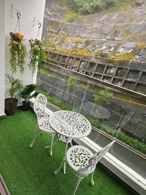 two chairs and a table on a balcony at Cameron Palas Homestay in Brinchang