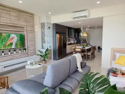 a living room with a blue couch and a kitchen at NEW Sunrise Gurney with SEAVIEW \u65e0\u654c\u65e5\u51fa\u6d77\u666f in George Town