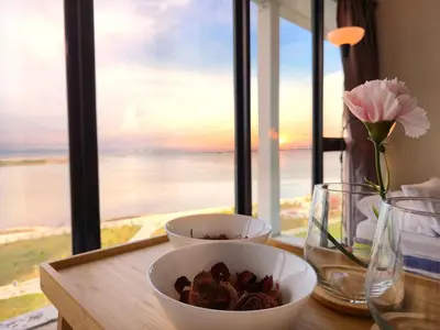 a table with two bowls and a vase with flowers at NEW Sunrise Gurney with SEAVIEW \u65e0\u654c\u65e5\u51fa\u6d77\u666f in George Town