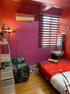a room with a bed and a red wall at Brite Homestay Nibong Tebal in Kampong Telok