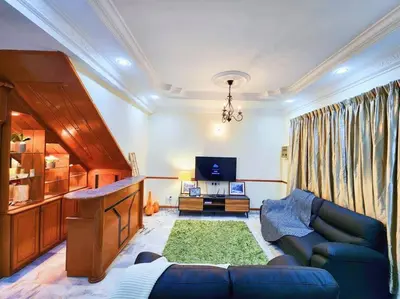 a living room with a blue couch and a television at Pengkalan 42 Double-Storey Homestay in Kampong Pinji