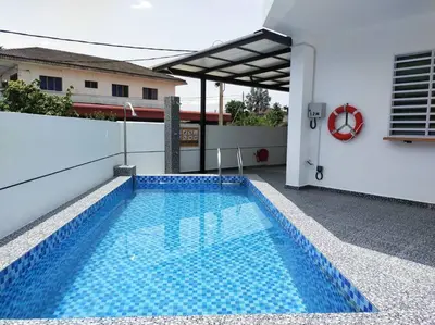 a swimming pool in the backyard of a house at Tints of Green Pool Bungalow-6 Bedroom-Karaoke-BBQ in Sultan Azlan Shah Airport