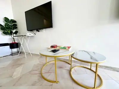 a living room with two tables and a flat screen tv at Stylish Cozy Landed Jelutong 3BR 2B 4CP-10pax by 3C in Jelutong