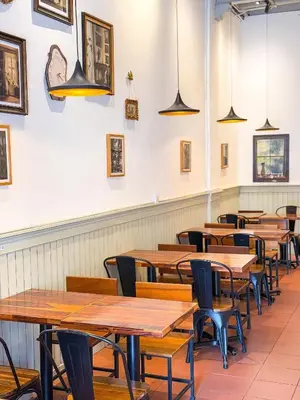 a row of tables and chairs in a restaurant at Moustachz Hauze , Georgetown in George Town
