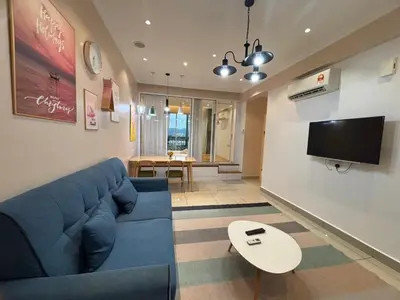 a living room with a blue couch and a tv at Ipoh Town Majestic Suites by IWH Suites in Ipoh