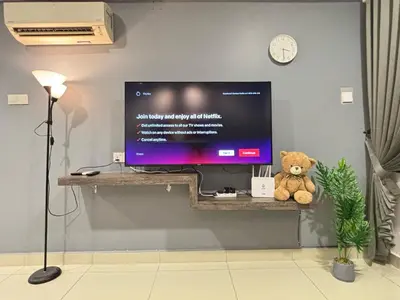 a teddy bear sitting on a shelf with a television at Ipoh Town Majestic Suites by IWH Suites in Ipoh
