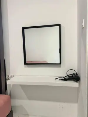 a mirror on a white wall in a room at Lily Brava 5 in Tanah Rata