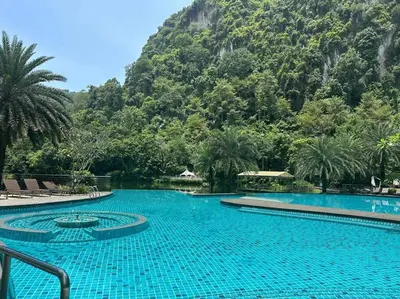 a large swimming pool with a mountain in the background at Ipoh lakeside Suite Ipoh 4pax in Ipoh
