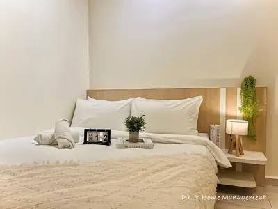 a bedroom with a large white bed with a clock on it at Kampung Paloh Residence Ipoh with 2 Parking & Free Netflix in Ipoh