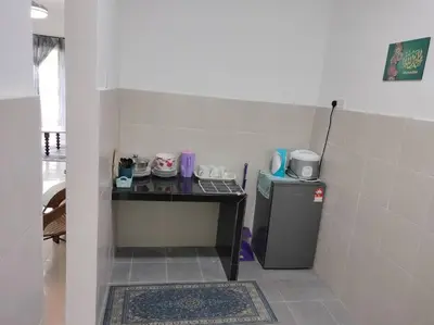 a room with a table and a small refrigerator at Ammara Homestay Emerald Avenue Cameron Highlands in Brinchang
