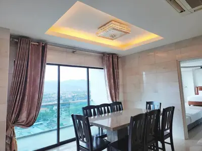 a dining room with a table and chairs and a window at Ipoh Kinta river front luxury pent house 4br 18pax in Ipoh