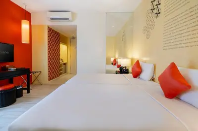 a bedroom with a large white bed with red pillows at Hotel 19, Penang in George Town