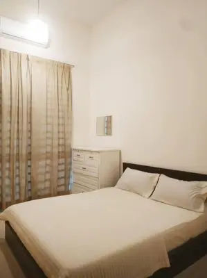 a bedroom with a white bed and a window at Setia Homestay Chemor Setia in Chemor