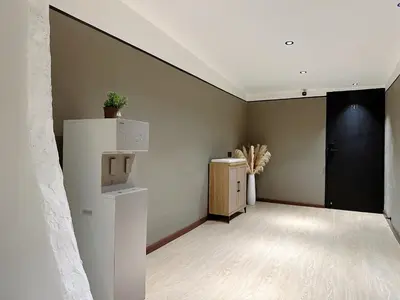an empty room with a refrigerator and a black door at The Jubilee Guest House in Ipoh