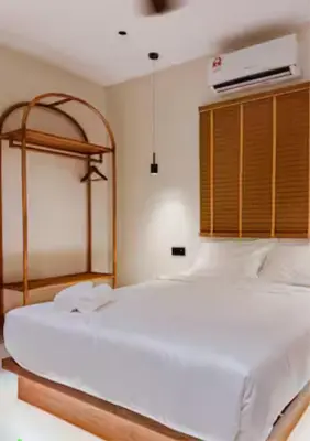 a bedroom with a large white bed with a wooden headboard at Ipoh Tiga Pool Villa by Papahost in Ipoh