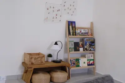 a room with a table and a shelf with books at Homestay Bukit Mertajam - DHome in Bukit Mertajam