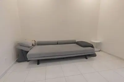 a couch sitting in a room with a white wall at Super Minimalist SP Town Centre in Sungai Petani