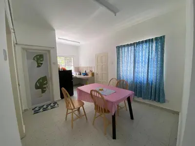 a dining room with a pink table and chairs at Rumah Bukit Jalan Kolam Air in Kuala Kubu Baharu