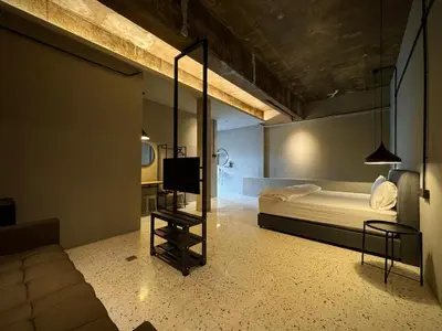 a bedroom with a bed and a table and a chair at M2 Living Townhouse in Ipoh in Ipoh