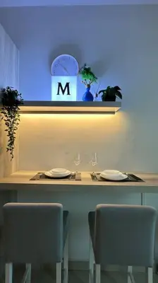 a table with two chairs and a clock on the wall at Seaview Seafront Duplex in Town with WiFi & Full Kitchen 66 in Georgetown