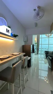 a kitchen with a counter and chairs in a room at Seaview Seafront Duplex in Town with WiFi & Full Kitchen 66 in Georgetown