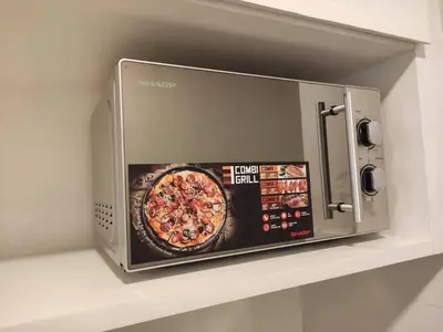 a microwave oven on a shelf with a pizza at Heritage House 3BR in Town walkto UNESCO Site & StreetArt 47 in George Town