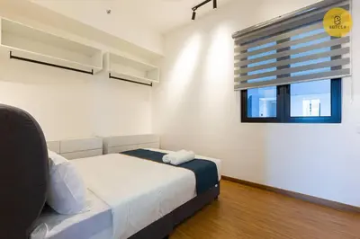 a white bedroom with a bed and a window at Seaview 2BR Infinity Pool & EasyAccess to Town 13A in George Town