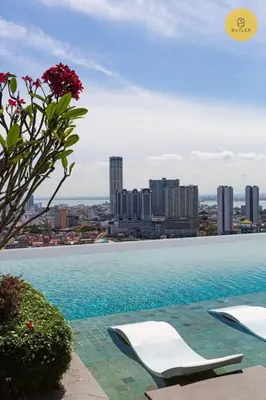 a swimming pool with two lounge chairs and a city at Seaview 2BR Infinity Pool & EasyAccess to Town 13A in George Town
