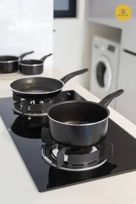 three pans sitting on a stove in a kitchen at Greatview 2BR Infinity Pool & EasyAccess to Town 13 in George Town