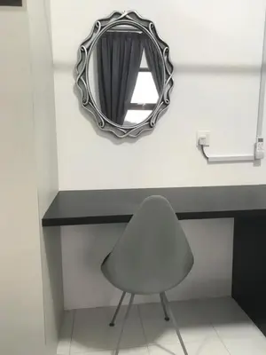 a mirror and a chair in front of a counter at DyMaz Salam Homestay in Seri Iskandar