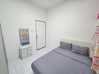a bedroom with a bed and a mirror and a tv at Sunny Point Hostel in Gelugor