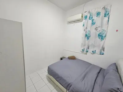 a bedroom with a bed in a white room at Sunny Point Hostel in Gelugor