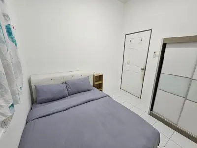 a bedroom with a bed with blue sheets and a mirror at Sunny Point Hostel in Gelugor