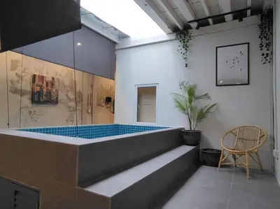 a bathroom with a tub with a chair and a table at Heritage House 4BR with Dipping Pool, Central Location Near Street Art 45 in George Town