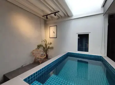 a small swimming pool in a white room with a blue tile floor at Heritage House 5BR with Dipping Pool, Central Location Near Street Art 47 in George Town