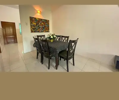 a dining room with a table and chairs with flowers on it at Santai Impian Meru Ipoh in Ipoh